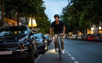 Fietser in de duisternis op de openbare weg met helm en fietsverlichting